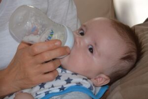 Bébé qui boit un biberon de lait